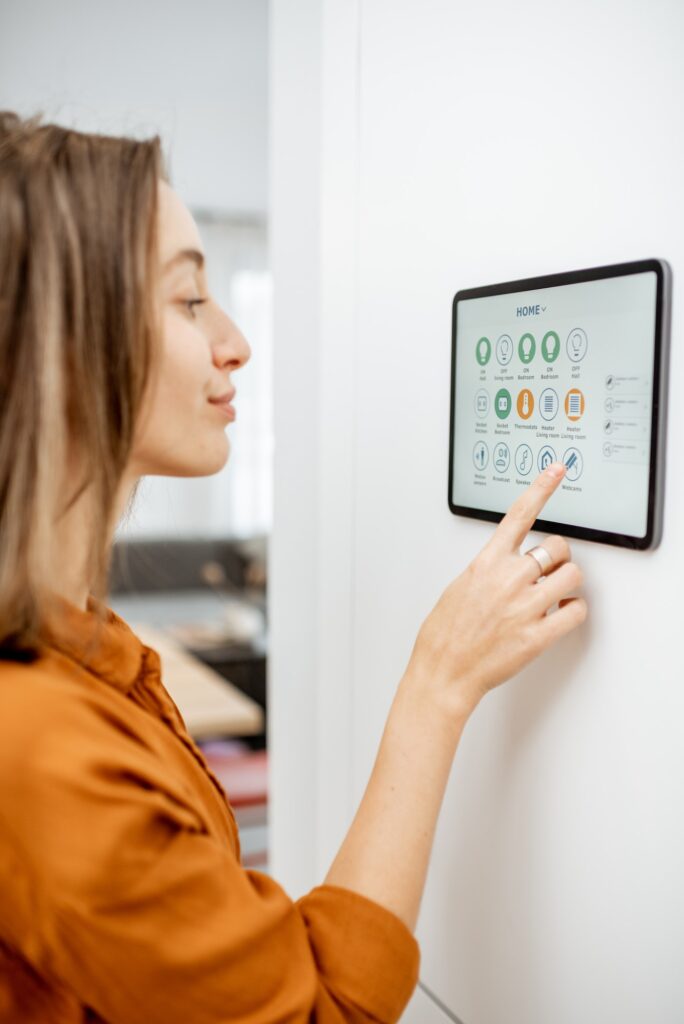 Woman controlling smart devices with a digital tablet at home